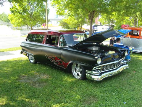 2007 Ford Mustang - Customized 1956 station wagon with flame decals and chrome wheels sits on display at an outdoor event.