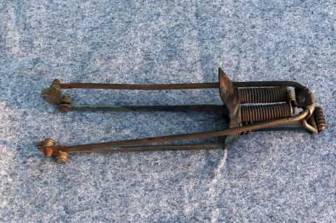 1994 Ford Bronco - This rusted metal spring mechanism appears to be a component from a larger assembly.