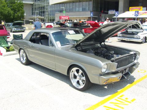 2007 Ford Mustang - A modified 1965 Ford Mustang coupe is displayed with its hood open at an outdoor car show.