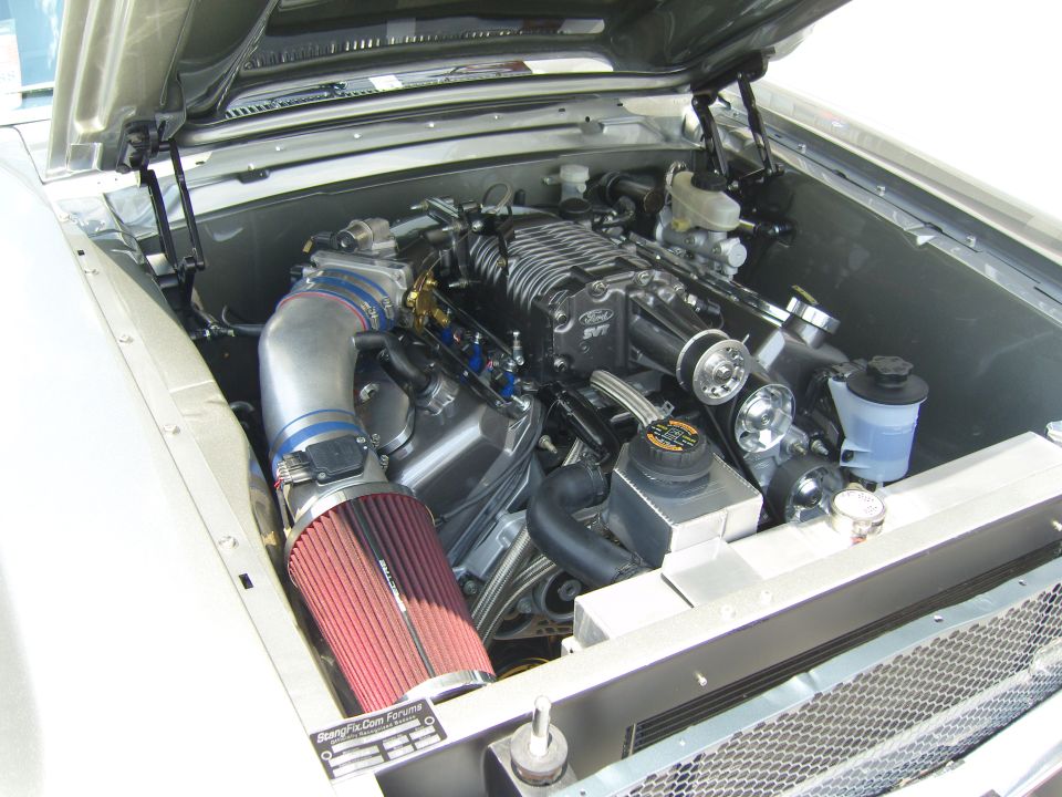 Engine bay with a supercharged V8, prominent air intake, and Ford SVT branding