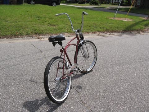 1994 Ford Bronco - Cruiser bicycle with tall handlebars and whitewall tires sits on a cracked asphalt road.