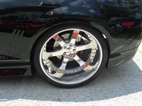 2007 Ford Mustang - Custom chrome wheel and tire assembly on a black vehicle.