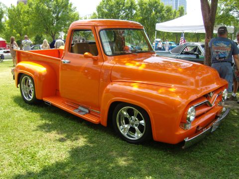 2007 Ford Mustang - This vibrant orange pickup truck features a classic 1956 body style with modern custom wheels and a lowered suspension.