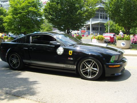 2007 Ford Mustang - A black 2007 Ford Mustang Shelby GT500 is seen from the side at a car show.