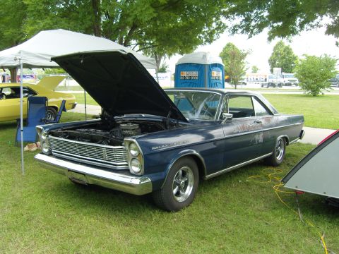 2007 Ford Mustang - A 1965 Ford Galaxie 500 is displayed with its hood up, next to a yellow car.