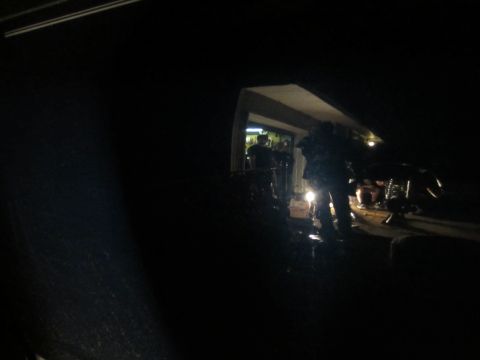 1992 Ford Bronco - Several individuals are gathered around a vehicle, illuminated by artificial light, during nighttime operations.