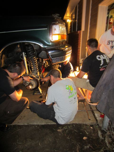1992 Ford Bronco - Several people are working on the front suspension of a 1992 Ford Bronco.