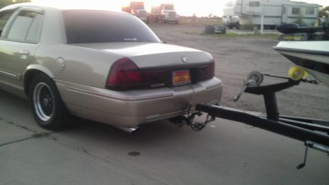 2000 Mercury Grand Marquis - A gold Mercury Grand Marquis is seen from the rear, hitched to a boat trailer.