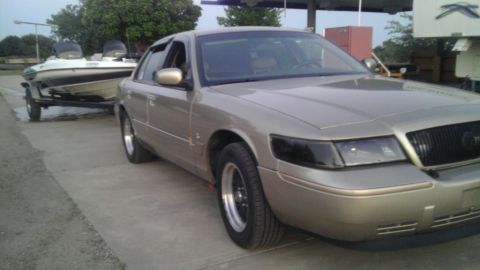 2000 Mercury Grand Marquis - A gold 2000 Mercury Grand Marquis is seen towing a boat on a trailer.