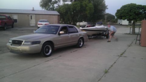 2000 Mercury Grand Marquis - A tan 2000 Mercury Grand Marquis is seen towing a boat on a trailer.