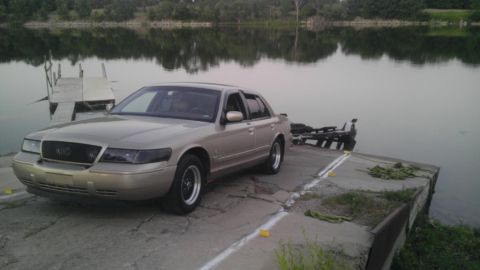 2000 Mercury Grand Marquis - Gold 2000 Mercury Grand Marquis sedan parked on a boat ramp by a lake.