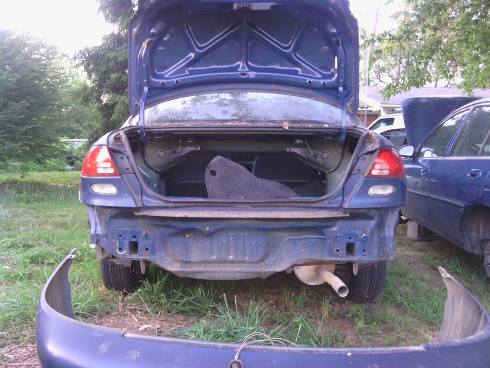 blue sedan, trunk open, bumper removed, parked next to another blue car