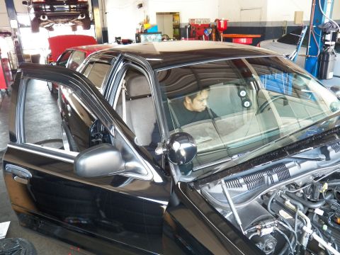 2003 Ford Crown Victoria - Close side view of a Crown Victoria with a person in the driver seat and a pillar spotlight.