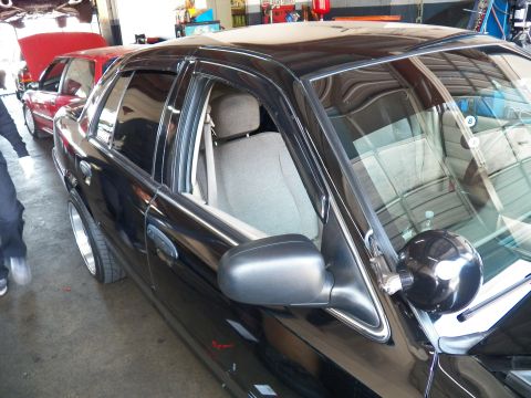 2003 Ford Crown Victoria - Driver-side shot of a Crown Victoria in a garage showing window deflectors and a pillar spotlight.