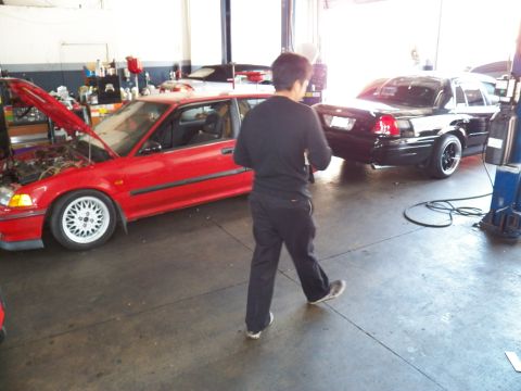 2003 Ford Crown Victoria - Garage scene with a black Crown Victoria, a red Civic hatchback and a person crossing the floor.