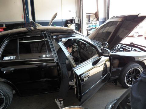 2003 Ford Crown Victoria - Side profile of a black Crown Victoria mid-service, door open and engine bay exposed
