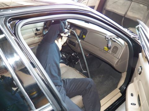 2003 Ford Crown Victoria - Technician at the wheel area of a beige-interior sedan with center display lit