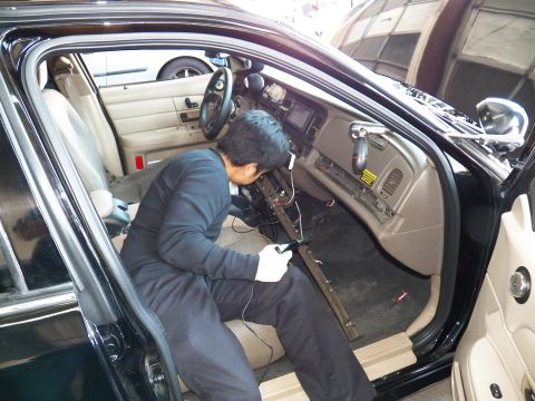 2003 Ford Crown Victoria - Technician works the center console of a Crown Victoria with the door sill panel off