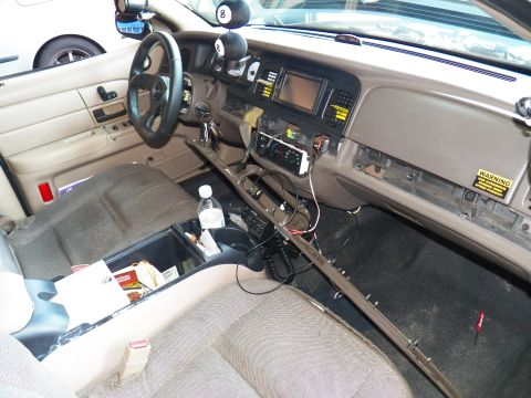 2003 Ford Crown Victoria - Dashboard and console of a sedan mid-install, snacks and water in the center tray