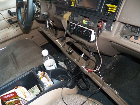 2003 Ford Crown Victoria - HVAC controls and tangled harness exposed in the dash of a tan-interior Crown Victoria