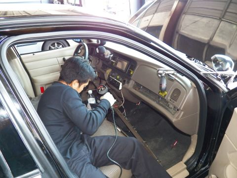 2003 Ford Crown Victoria - Technician reaches into the dash of a Crown Victoria, water bottle on the floor