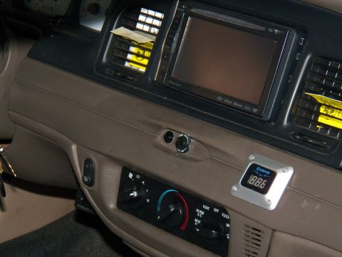 2003 Ford Crown Victoria - Aftermarket double-DIN screen sits above a digital voltage gauge and rotary climate dials.