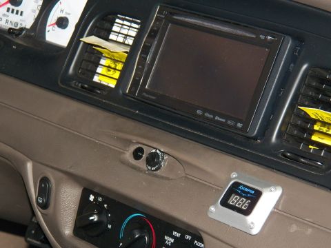 2003 Ford Crown Victoria - Close view of aftermarket Pioneer head unit and voltmeter mounted in a tan dashboard.