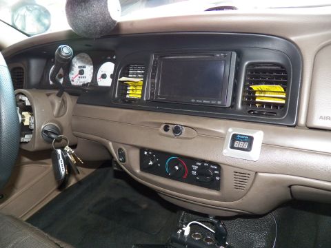 2003 Ford Crown Victoria - Driver-side dash showing instrument cluster, center screen, and ignition keys in a sedan.