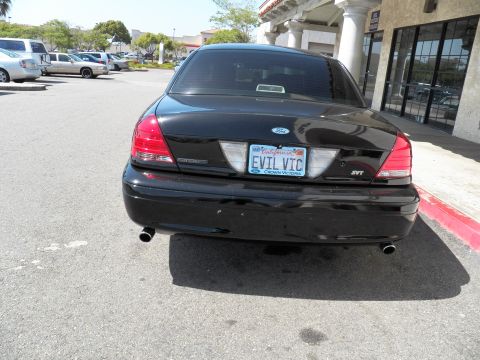 2003 Ford Crown Victoria - Tail end of a black Ford Crown Victoria with SVT badge, EVIL VIC plate and twin exhaust pipes