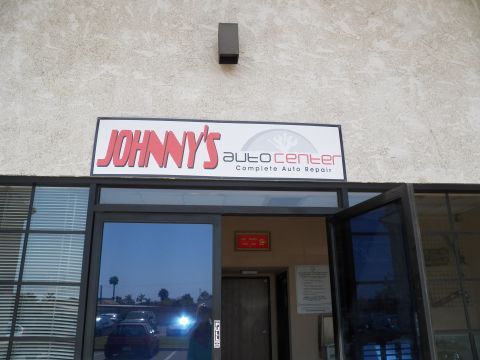 2003 Ford Crown Victoria - Exterior signage for Johnny's Auto Center, Complete Auto Repair, mounted above the shop's glass doors