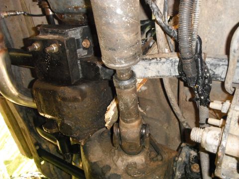 1988 Ford Bronco - Close-up view of the underbody, showing drivetrain parts and a black wiring harness secured with tape.