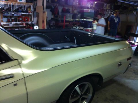 1976 Ford Ranchero - The rear side panel and bed of a pickup truck are visible in a garage setting with tools on the wall.