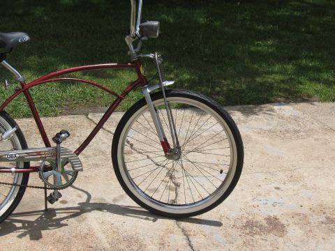 1994 Ford Bronco - A red cruiser bicycle with a whitewall tire is shown from the front quarter, focusing on the wheel and frame.