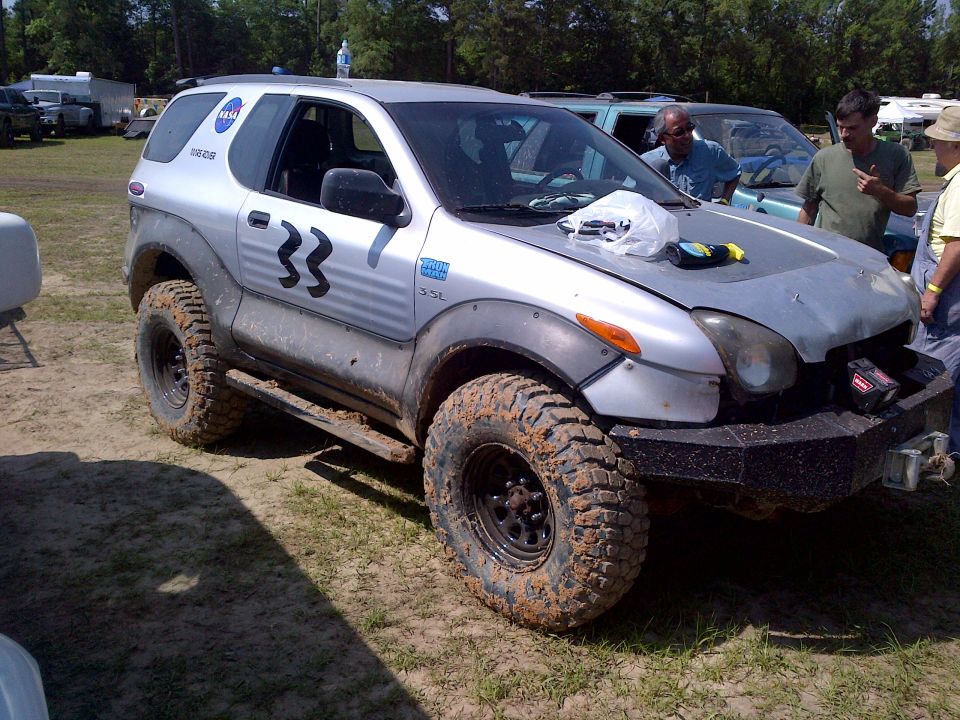 Silver 1999 Isuzu Vehicross with number 33 on the door and NASA logo on the rear window, fitted with large off-road tires