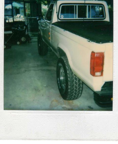 1999 Ford Ranger - Polaroid photo of a two-tone tan Ford pickup's rear quarter and bed with chrome wheels parked in a garage.