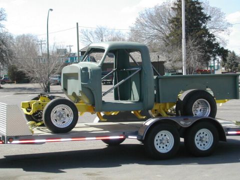 1965 Ford Fairlane - A custom truck chassis is transported on a flatbed trailer.