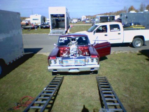 1965 Ford Fairlane - A 1965 Ford Fairlane drag car is shown from the front with its hood open, revealing a powerful engine, ready for the track.