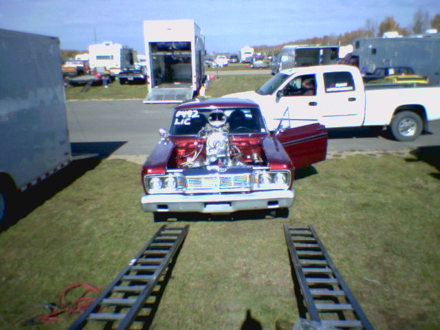 1965 Ford Fairlane drag car front view, exposed engine, red