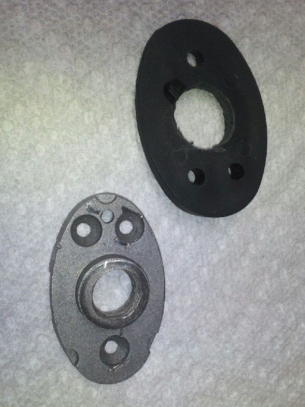 Two metal and rubber automotive parts on a textured surface