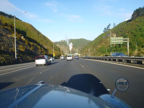 1969 Lincoln Continental - A scenic drive on a highway, with several cars on the road and lush green hills on either side.