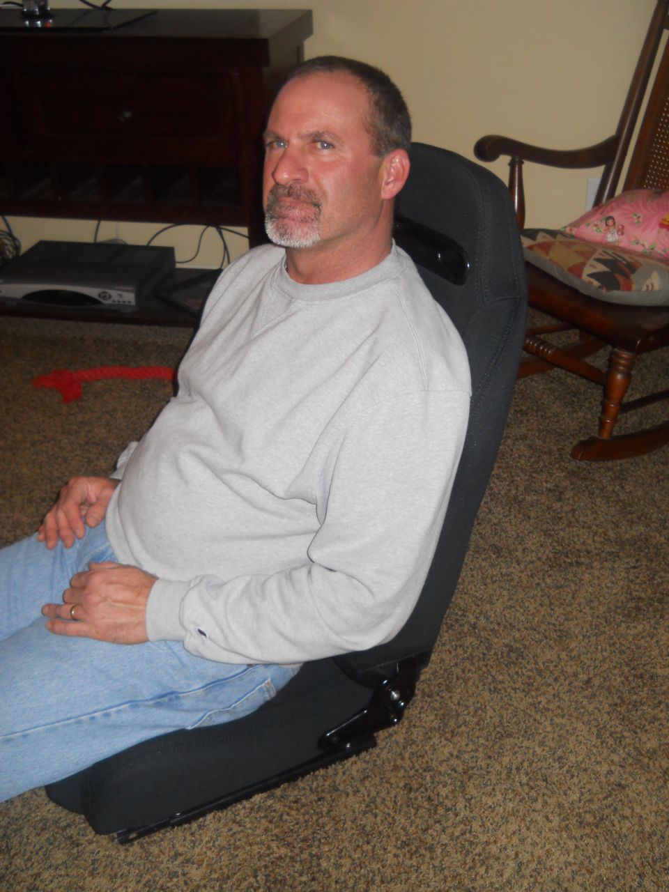 Black racing seat with metal frame, man sitting in it