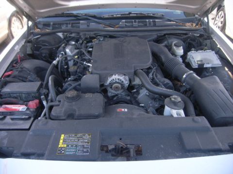 2005 Ford Crown Victoria - The engine bay of a 2005 Ford Crown Victoria is viewed from above, revealing its V8 engine components and associated systems.