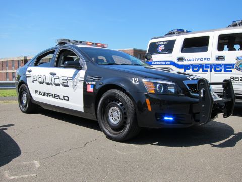 1991 Ford LTD Crown Victoria - Black-and-white Chevrolet Caprice police car marked POLICE Fairfield with a push bumper, a white Hartford Police SUV behind it.