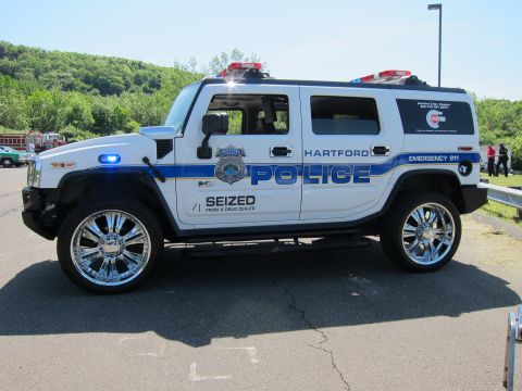 1991 Ford LTD Crown Victoria - Side profile of a white and blue Hummer H2 marked HARTFORD POLICE and SEIZED from a drug dealer on large chrome wheels.