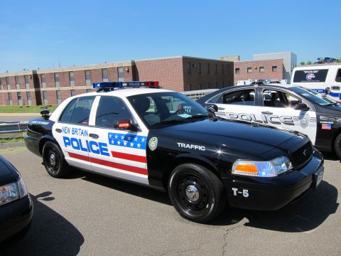 1991 Ford LTD Crown Victoria - New Britain Police Traffic Ford Crown Victoria marked T-5 with flag graphics, parked among other police cars.
