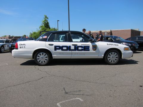 1991 Ford LTD Crown Victoria - Side view of a white Meriden Police Supervisor Crown Victoria with officers gathered beside it on pavement.
