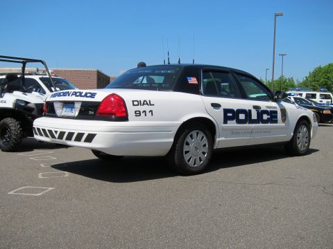 1991 Ford LTD Crown Victoria - Rear three-quarter view of a white Meriden Police Crown Victoria marked Dial 911 in a lot with other units.