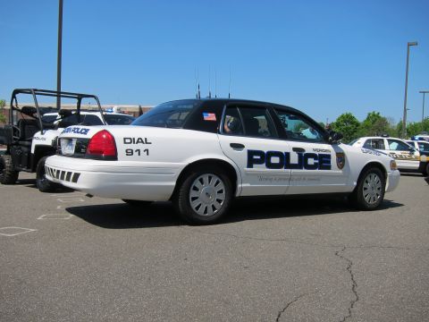 1991 Ford LTD Crown Victoria - white Meriden Police Crown Victoria viewed from the rear, parked near a police utility ATV and other cars.