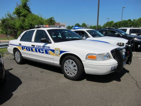 1991 Ford LTD Crown Victoria - Front-quarter view of a white State Capitol Police Ford Crown Victoria with brush guard among other police cars.