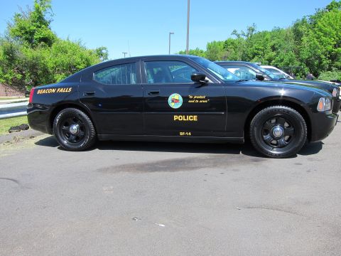 1991 Ford LTD Crown Victoria - Full side profile of a black Beacon Falls Police Dodge Charger with gold lettering and seal in a parking lot.